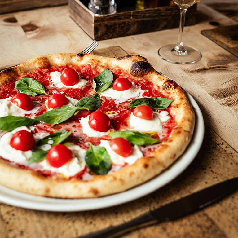 Pizza margarita mit Tomaten, Basilikum und Mozzarella